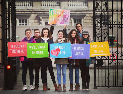 Irish young adults hold pro-life signs