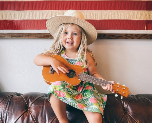 A preschooler with a cowboy hat and guitar