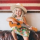 A preschooler with a cowboy hat and guitar