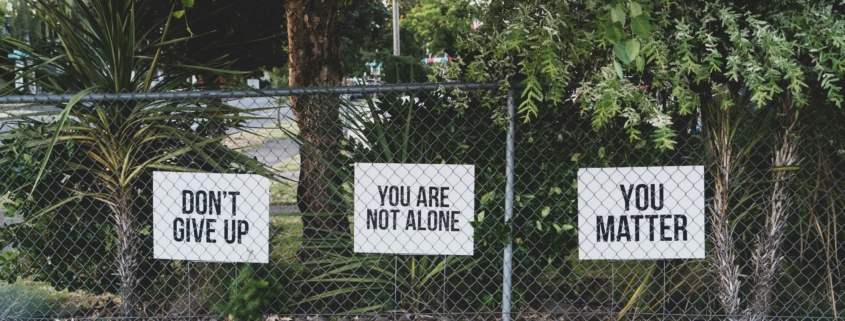 Signs on a fence display mental health messages
